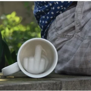 Tasse blanche en céramique avec le doigt